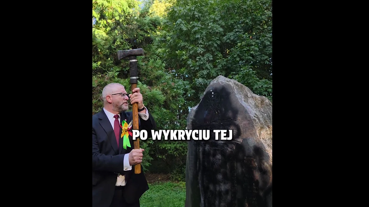 Гжегож Браун із молотом біля гранітного обеліска з викарбуваними іменами українців